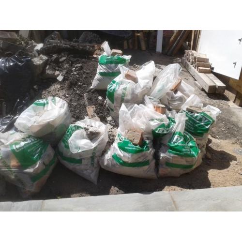 Concrete posts and panels and bags of loose rubble ,