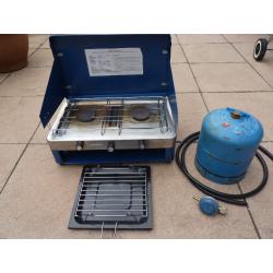 Camping stove with 2 burners and grill, gas bottle included.