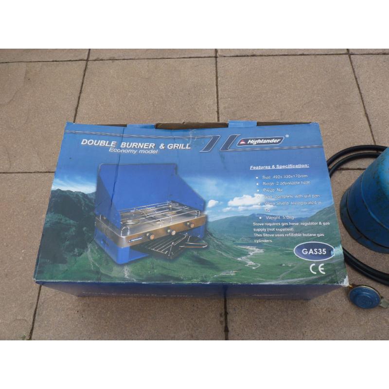 Camping stove with 2 burners and grill, gas bottle included.