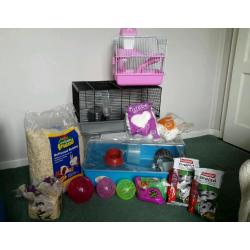 3 Different-sized Hamster cages, with food, balls, sawdust and fluffy bedding.