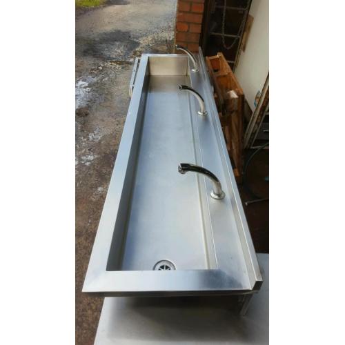 Stainless steel knee operated sink.