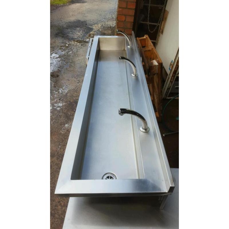 Stainless steel knee operated sink.